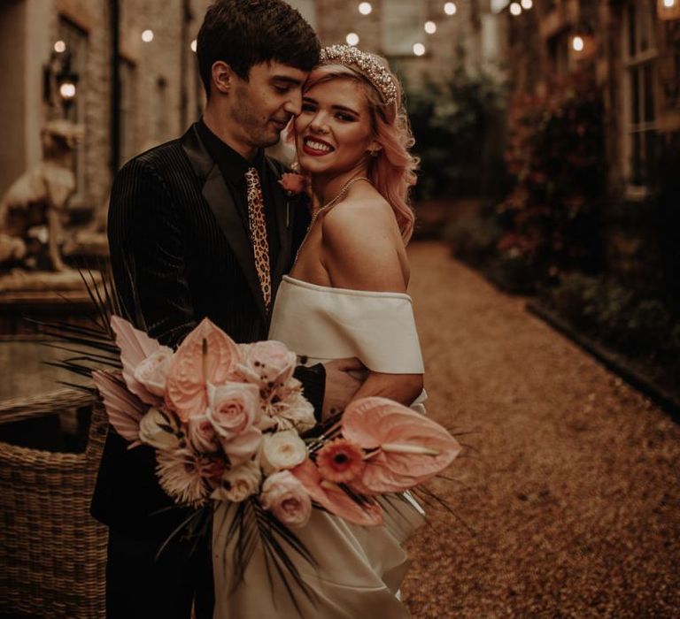 Stylish bride in headband holding a tropical bouquet with anthuriums