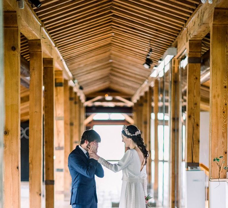 Emotional groom in navy suit at first look