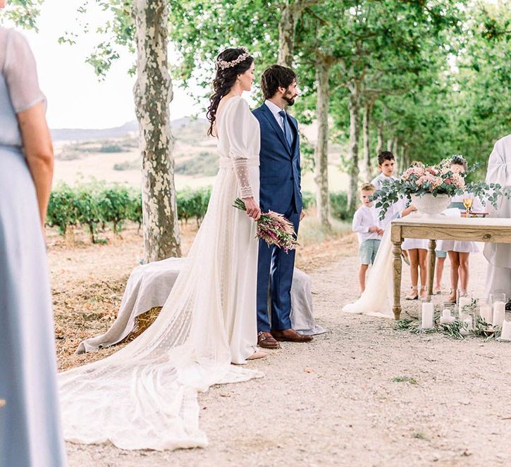 bride and groom standing at the altar of the wedding ceremony with the bride holding an astilbe wedding bouquet