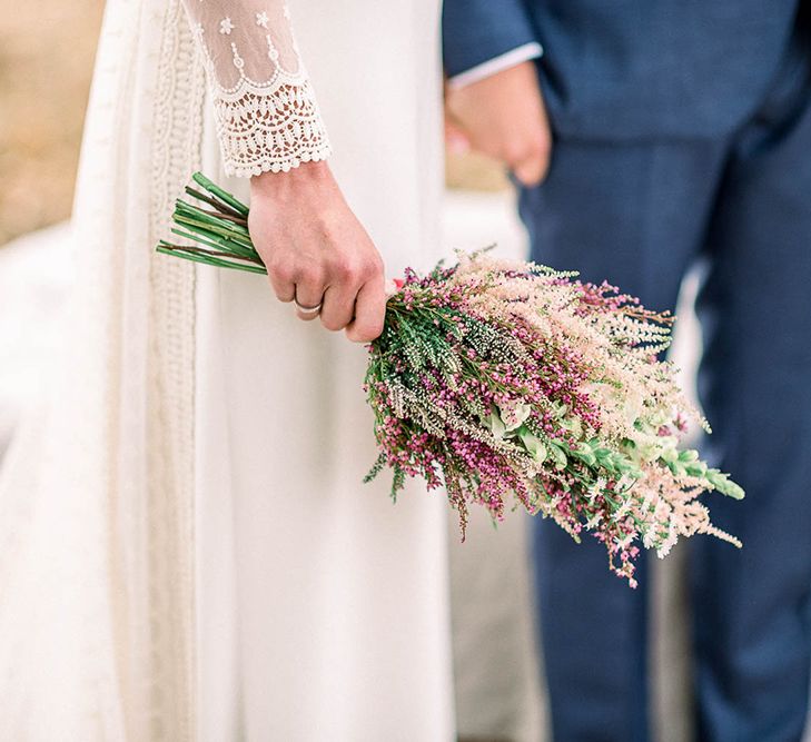 Bride in lace cuff sleeve wedding dress holding an astilbe wedding bouquet