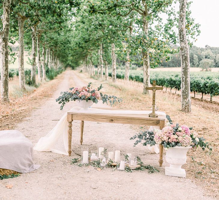 Romantic altar wedding decor with hay bale, and pink floral arrangements