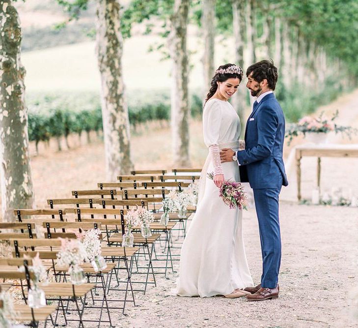 Bride and groom standing in the aisle holding an astilbe wedding bouquet