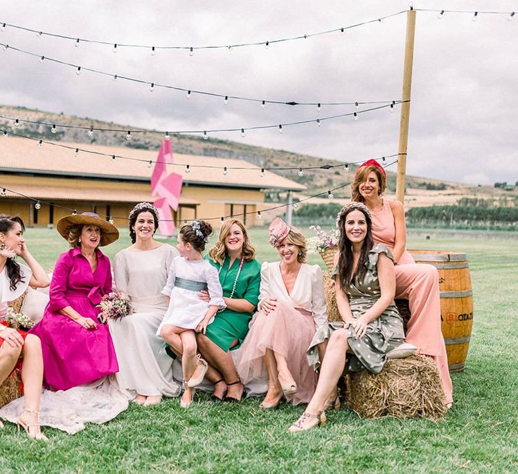 Female wedding guests sitting on a hay bale seating area