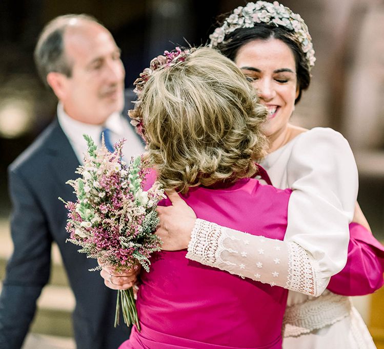 Bride hugging a wedding guest holding her astilbe wedding bouquet