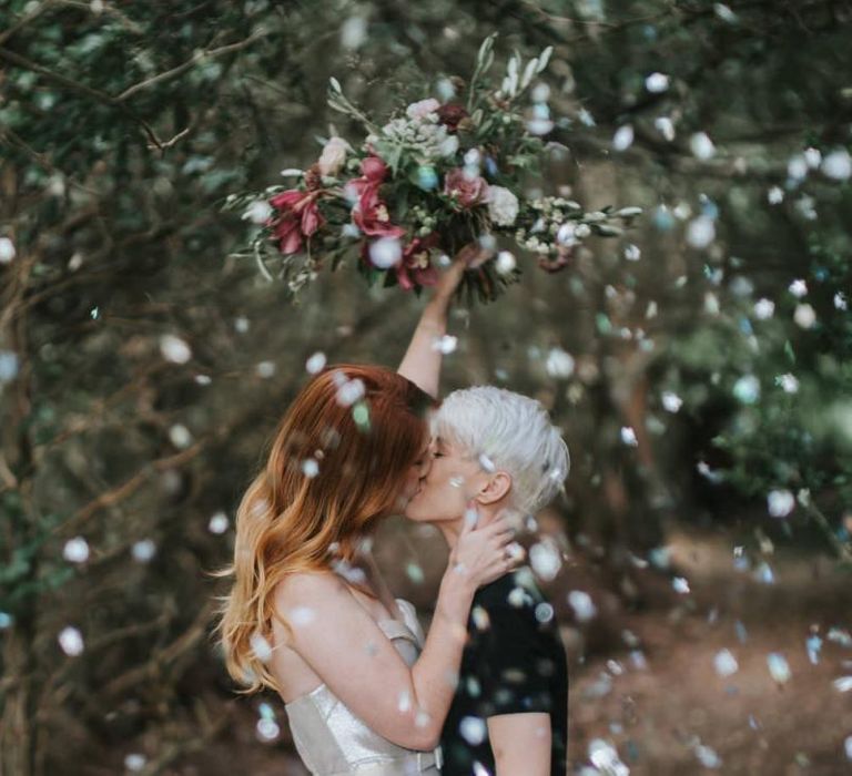 Brides kissing during confetti moment