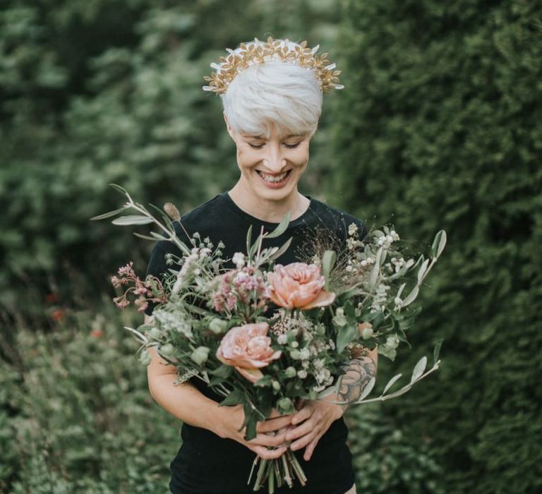 Bride with short hair wearing a gold crown and holding a bridal bouquet