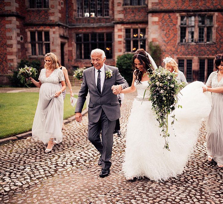 Bridal party walking through Dorfold Hall wedding venue grounds