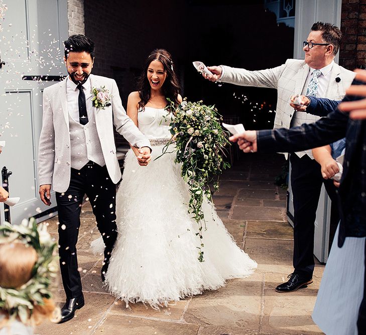 Confetti moment with bride in separates and groom in grey blazer