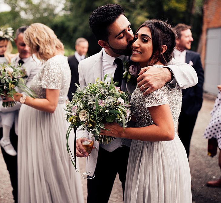 Groom kissing his bridesmaid sister on the cheek