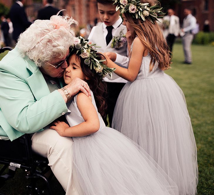 Gran kissing her flower girl grand daughter on the cheek