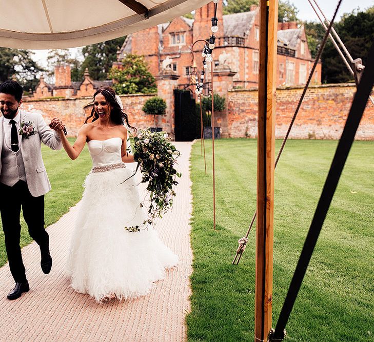 Bride and groom entering the marquee wedding reception