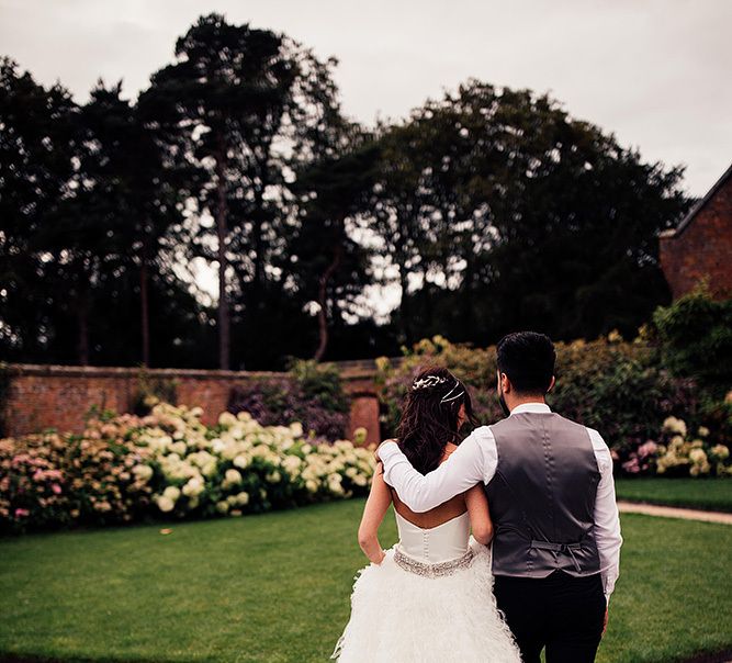 Romantic portrait of bride and groom showing off the brides Pronovias skirt