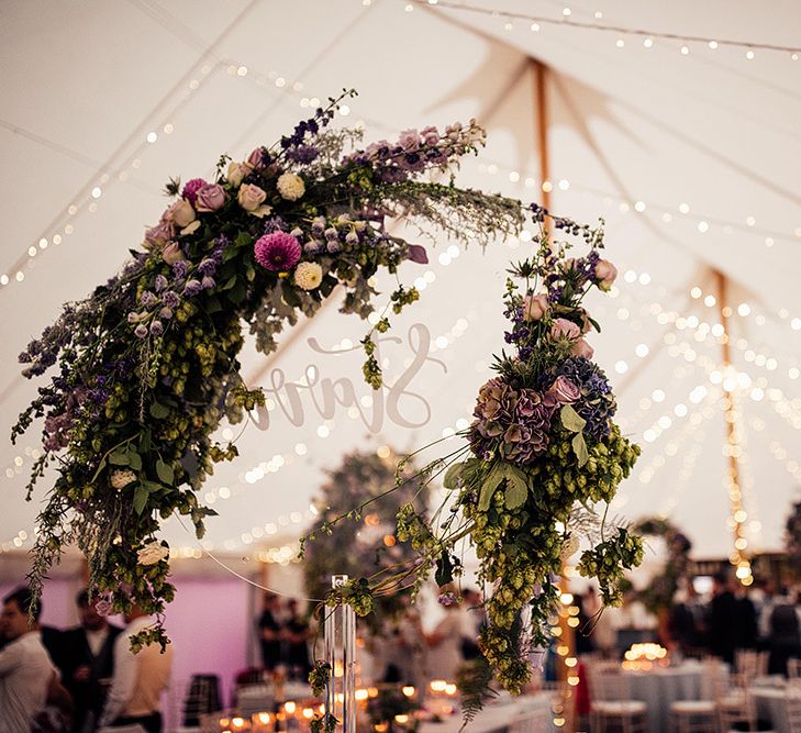 Acrylic wedding sign decorated with lilac wedding flowers and foliage