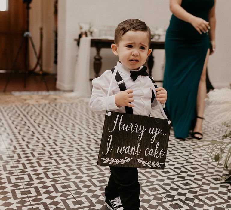 Cute page boy carrying wedding sign