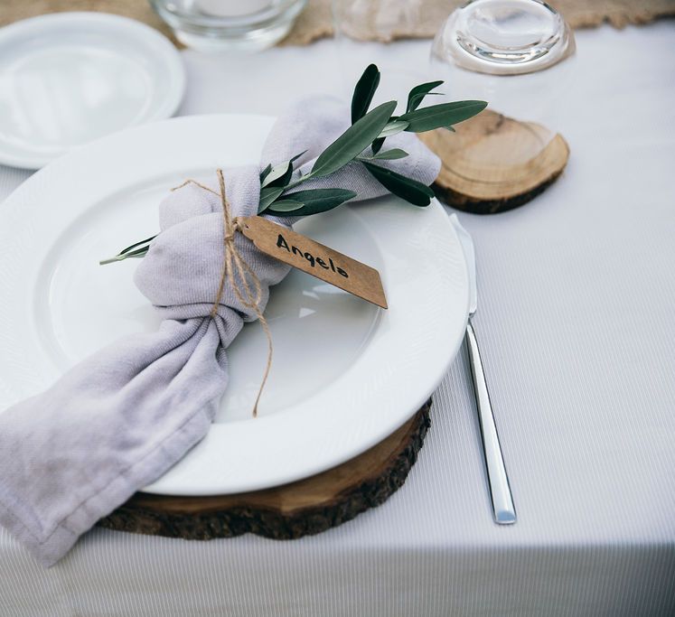 Outdoor Wedding Reception Decor at Tenuta Tresca | Wood Slice Place Mats | Knotted Lilac Napkin with Greenery | Kraft Label and Twine | Puglian Countryside Wedding with Fairy Light Altar and Olive Grove Aperitivo | Figtree Wedding Photography