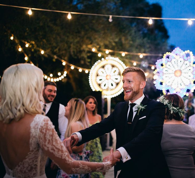 Dancing in the Courtyard at Tenuta Tresca | Giant Traditonal Puglian Luminare Lights | Groom in Dark Navy Hugo Boss Suit with Waistcoat and Black Patent Shoes by Common Projects | Fairy Light Moon Gate | Puglian Countryside Wedding with Fairy Light Altar and Olive Grove Aperitivo | Figtree Wedding Photography