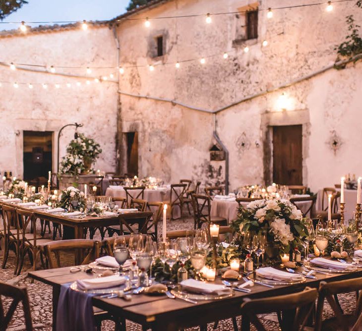 Outdoor Dining With Festoon Lights In Courtyard // Bride In Straw Hat With Leanne Marshall Wedding Dress Destination Wedding In Mallorca With Images From F2 Studios And Film By Alberto &amp; Yago