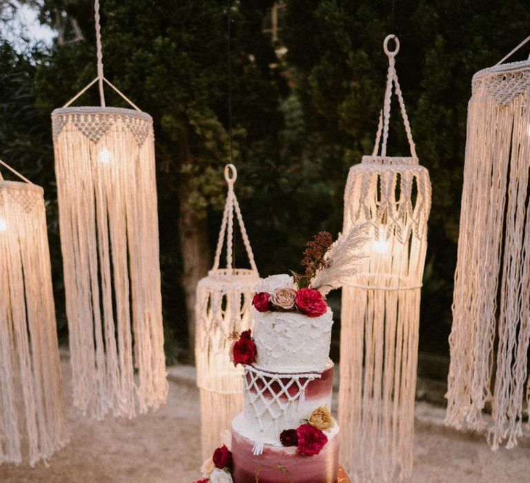 Red and White Wedding Cake with Macrame Detail in Front of Hanging Macrame Chandelier Backdrop