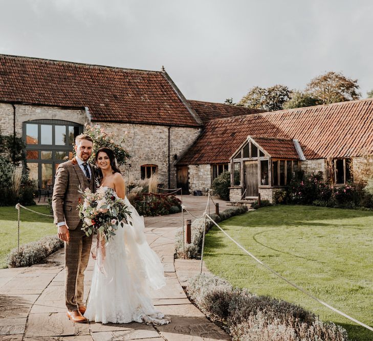 Bride and groom standing outside Priston Mill wedding venue