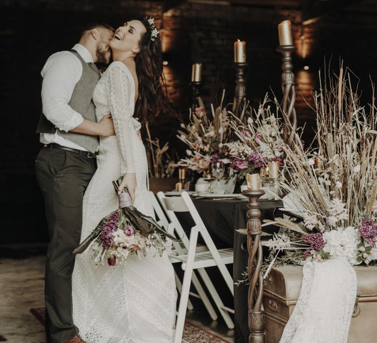 Boho Bride and Groom Standing Next to Tablescape and Dried Flower Arrangements