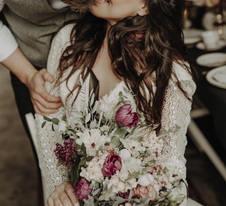 Groom in Wool Waistcoat Kissing Bride in Lace Wedding Dress