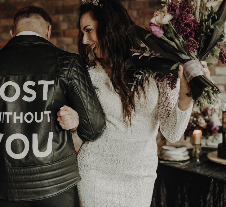 Groom in Personalised Leather Jacket  Linking Arms with Bride in Lace Wedding Dress