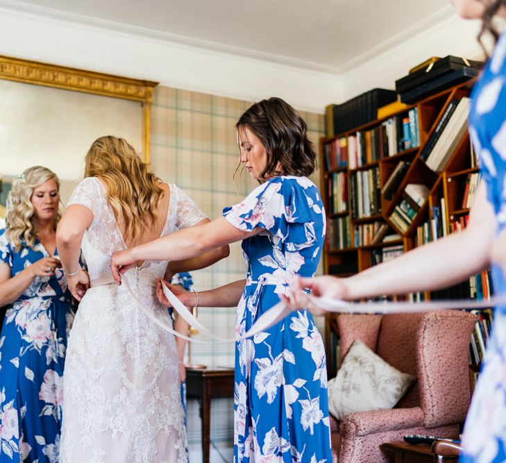 Wedding Morning Bridal Preparations with Bride in Lace wedding Dress and Bridesmaids in Floral Dresses