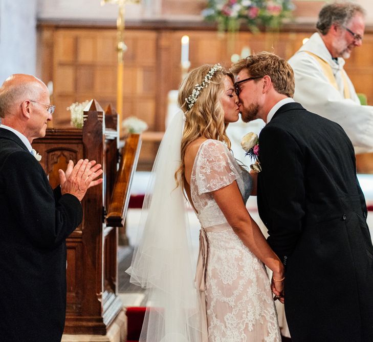 Bride in Lace Essence of Australia Wedding Dress and Groom in Morning Suit  Kissing at the Altar