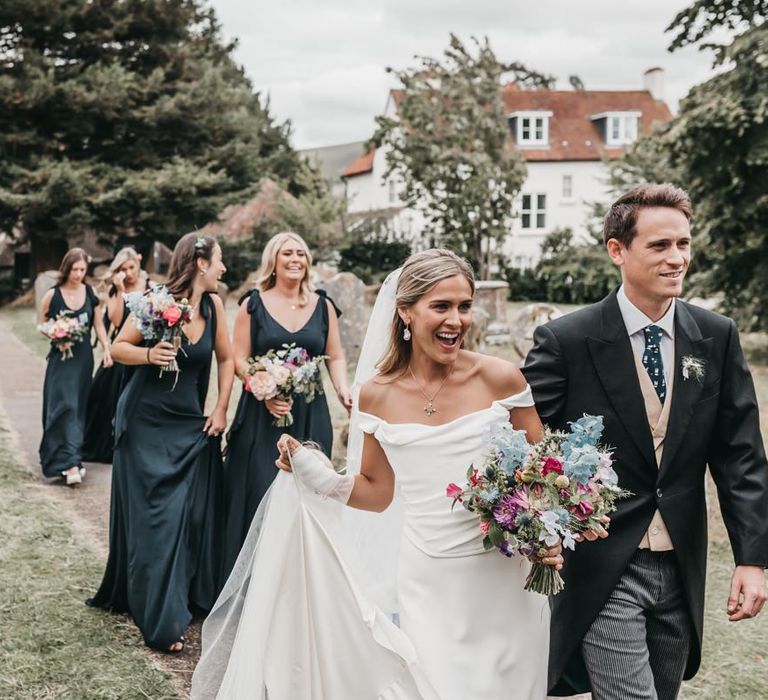 Bride in Halfpenny London wedding dress in church courtyard