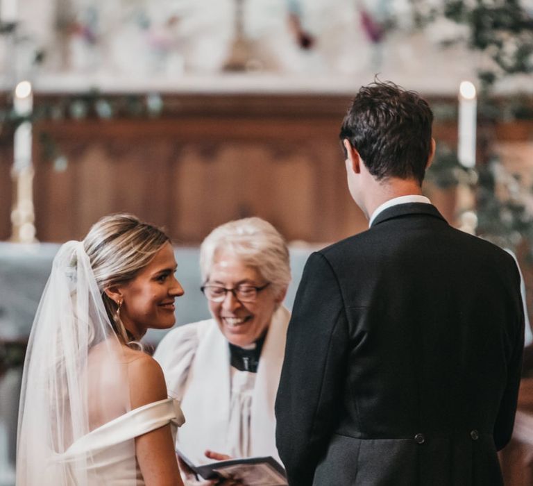 Bride and groom exchange vows during church wedding ceremony