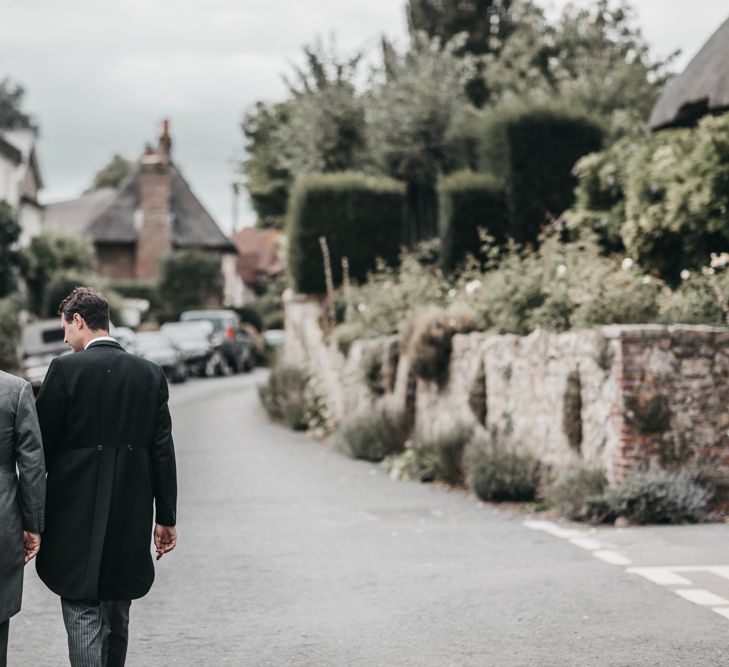 Groom and father of the groom walking down a country lane in traditional morning suit