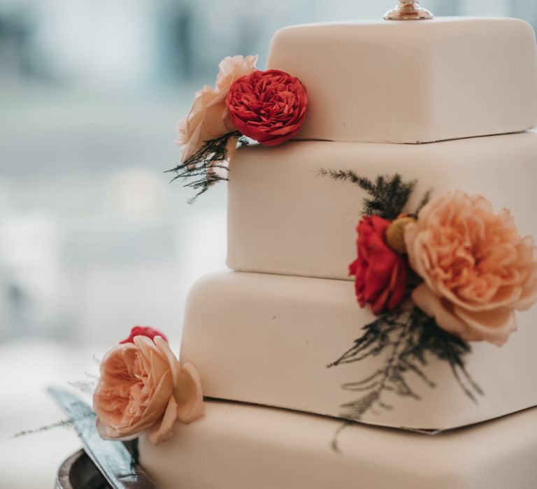 Homemade square royal icing wedding cake with flower decor