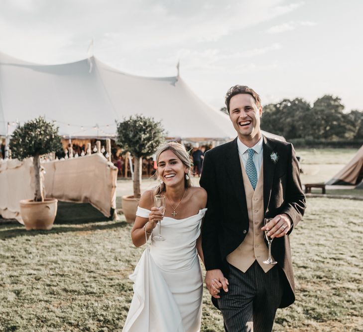 Bride and groom enjoying a drink at their outdoor Sperry tent reception