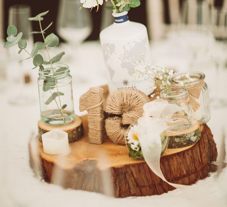 Rustic DIY Gin Bottle Centrepiece with Number Wrapped In Twine on a Tree Trunk Slice