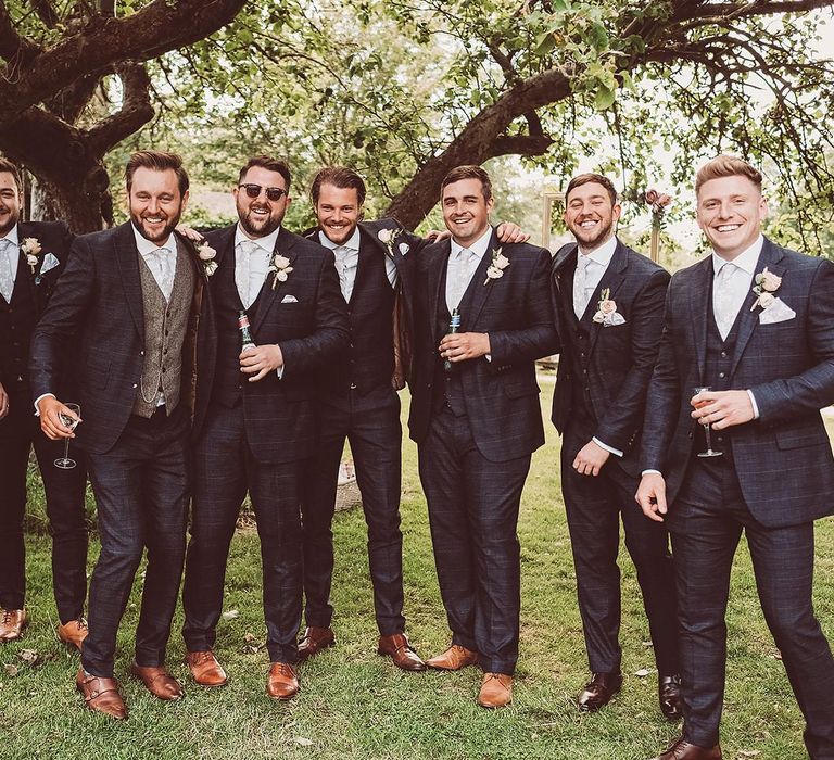 Groomsmen in Navy Check Suits and Brown Leather Shoes with Ties from Tie Garden featuring Groom in Wool Waistcoat