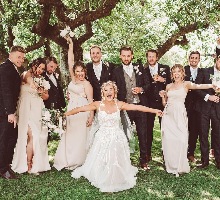 Wedding Party in Portrait with Bridesmaids Wearing Pink Dresses and Groomsmen in Navy Suits