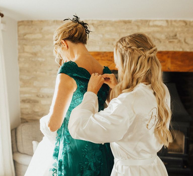 Bride helping her mum into her dress