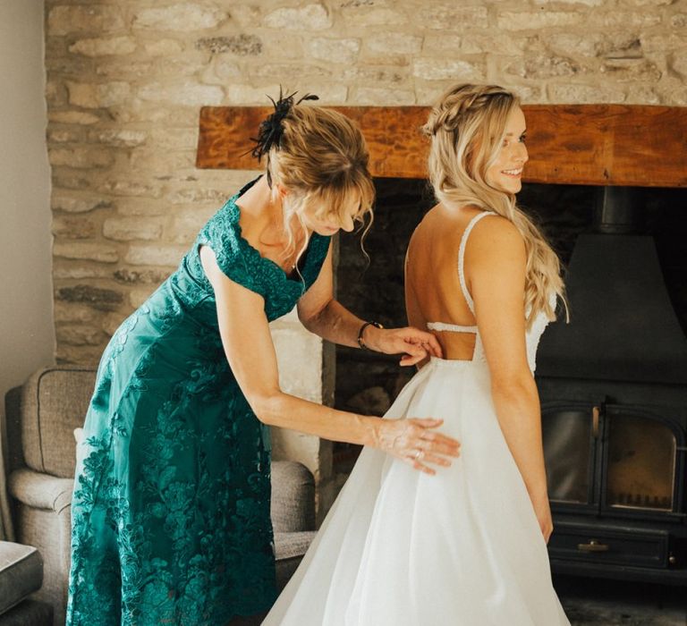 Mother of the bride helping her daughter into her dress