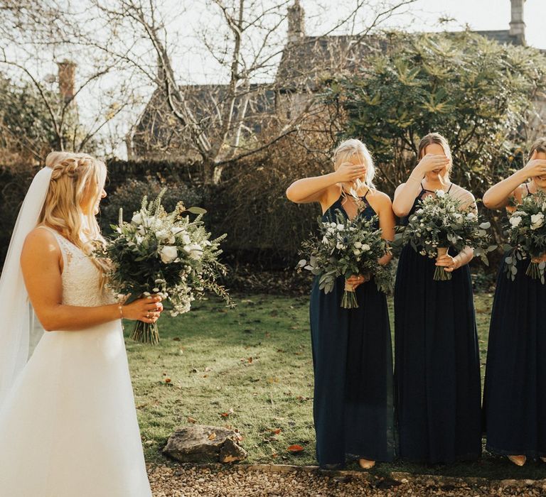 Bridesmaids in navy dresses first look of the bride