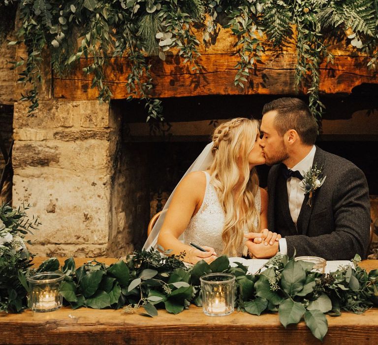 Bride and groom signing the register at Cripps Barn