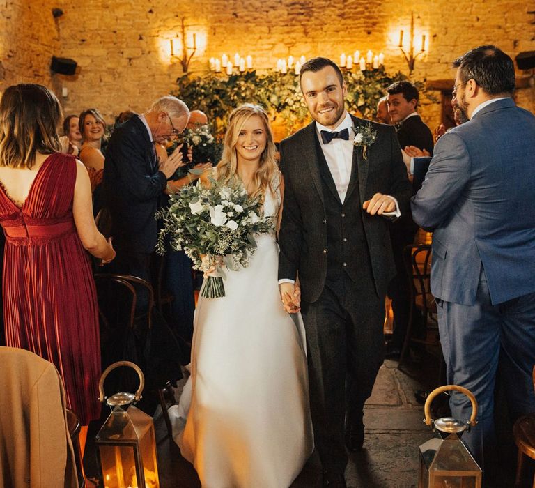 Bride and groom walking up the aisle as husband and wife