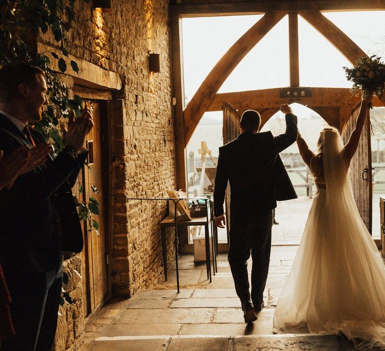 Bride and Groom exiting Cripps Barn after their November wedding  ceremony