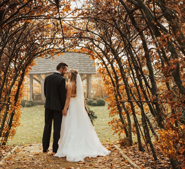 November wedding portrait with brown leaf tunnel