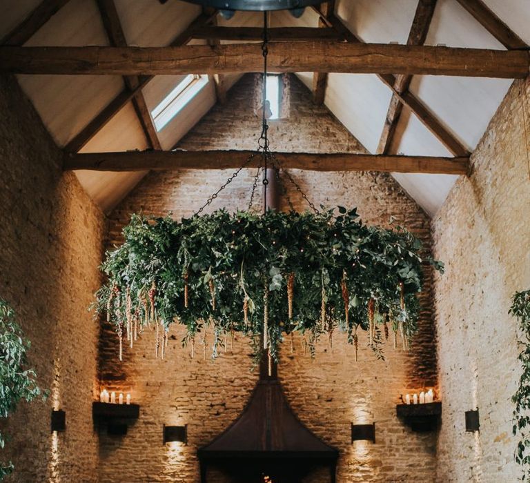 Stone Barn wedding ceremony decor with foliage chandelier