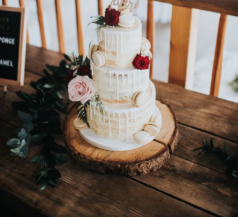 Semi-naked drip wedding cake at celebration with light box sign and pegboards