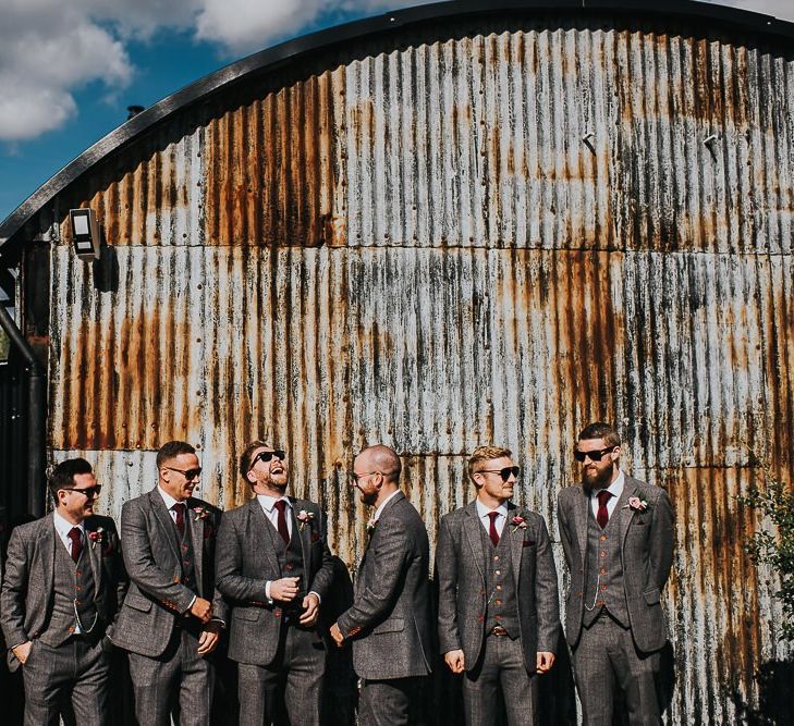 Groomsmen at Stone Barn wedding venue with light box sign and airstream photo booth