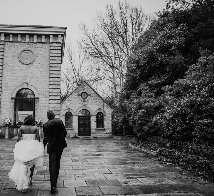 Bride and groom walking to their wedding ceremony at Pump House Gallery, Battersea Park, London