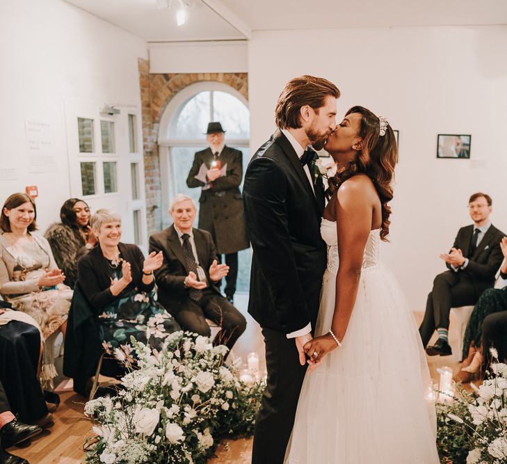 Bride and groom kissing at intimate Pump House Gallery wedding ceremony