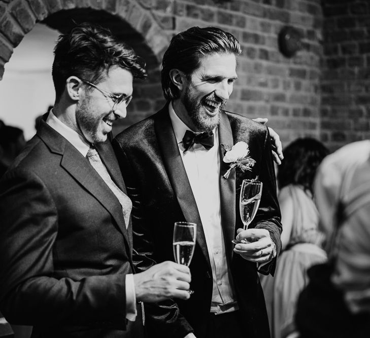 Groom laughing with wedding guests