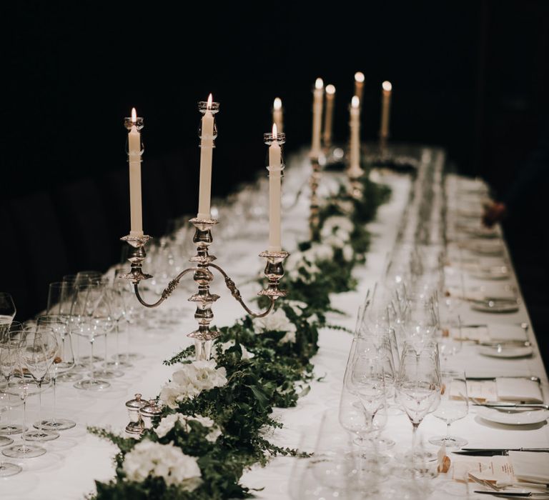 Greenery table runner with white flowers and candelabras